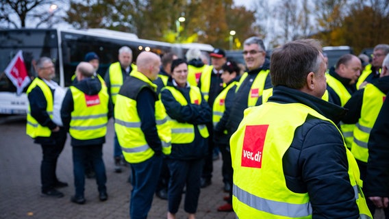 Streikende des Busgewerbes stehen in der Morgendämmerung auf dem Betriebshof. © dpa-Bildfunk Foto: Jonas Walzberg