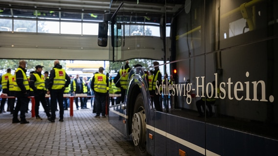 Bei einem Warnstreik stehen mehrere Menschen mit gelben Warnwesten neben einem Bus. © dpa Bildfunk Foto: Hannes P. Albert