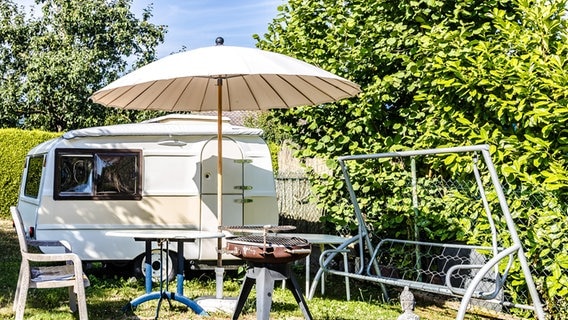 Ein Wohnwagen steht im Garten. © picture alliance / Shotshop | Birgit Reitz-Hofmann Foto: Birgit Reitz-Hofmann