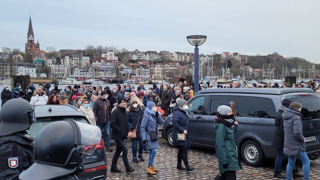Polizisten und Demonstranten sind im Flensburger Hafen bei einer Demo gegen die Corona-Maßnahmen der Regierung unterwegs.