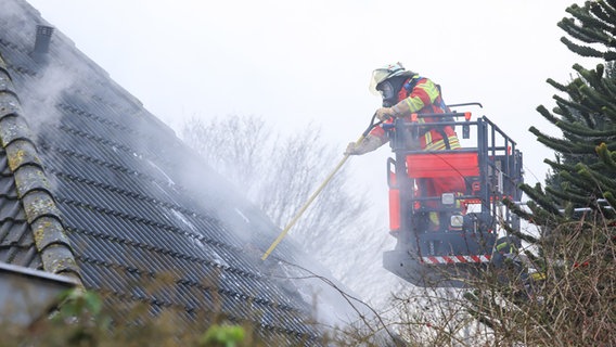 Ein Feuerwehrmann löscht einen Dachstuhlbrand in Itzehoe. © Florian Sprenger Foto: Florian Sprenger