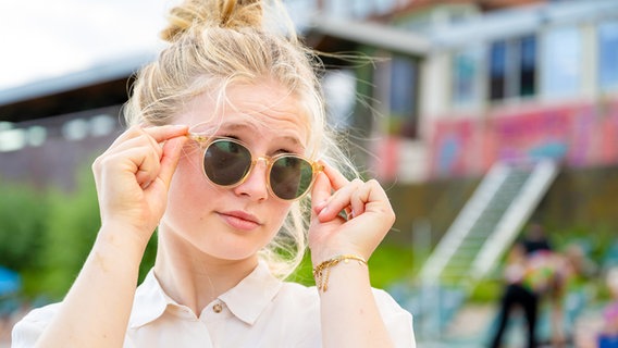 Eine junge Frau mit Sonnenbrille. © picture alliance / Connect Images | Pancake Pictures 