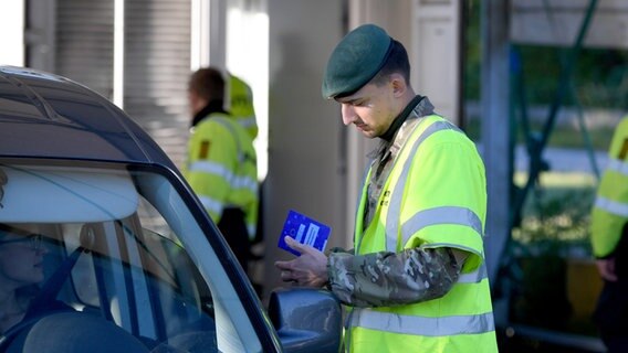 Beamte kontrollieren Reisende am Grenzübergang Krusau in Richtung Dänemark. © NDR Foto: Carsten Rehder/dpa