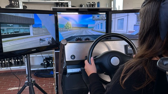 Eine Schülerin sitzt im ADAC-Autosimulator. © NDR Foto: Selma Zoronjić