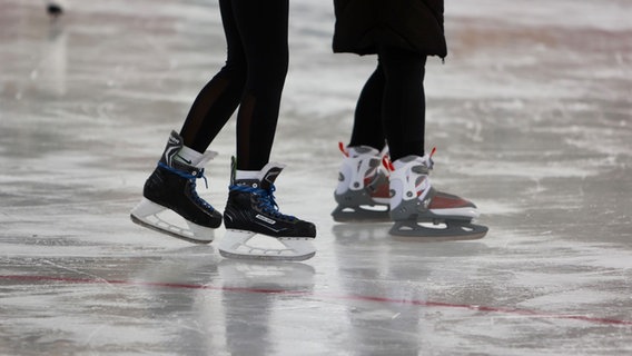 Besucher laufen mit Schlittschuhen über eine Eisfläche. © Picture Alliance Foto: Matthias Bein