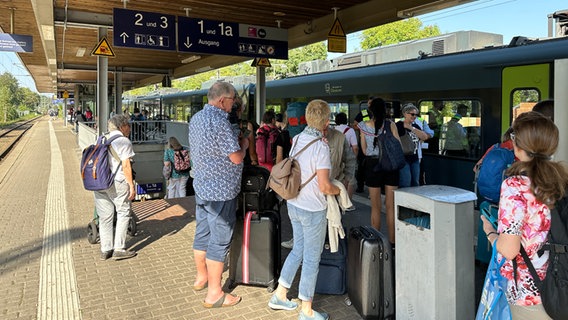 Bahnreisende stehen an einem Bahnsteig in Elmshorn. © NDR Foto: Samir Chawki