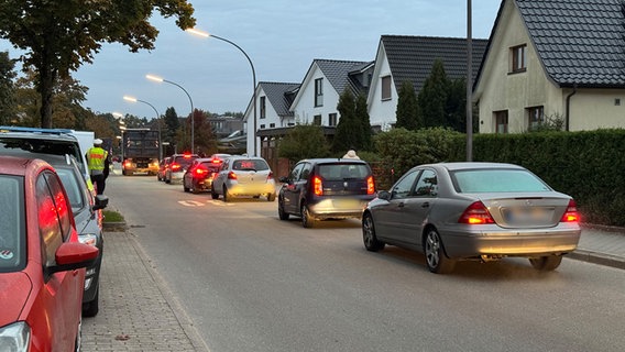 Autos stehen in der Morgendämmerung in einer Straße. © NDR Foto: Pia Klaus