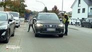 ein Polizist spricht mit einer Autofahrerin. © NDR 