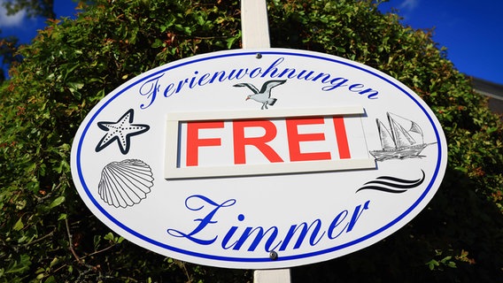 Auf einem Schild steht "Ferienwohnungen Zimmer frei". © picture alliance/dpa Foto: Christian Charisius