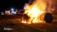 Einsatzkräfte der Feuerwehr löschen brennende Heuballen. © NDR 