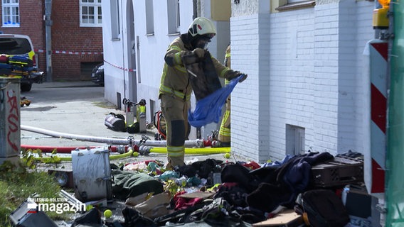 Ein Feuerwehr räumt eine Wohnung leer in Lübeck. © NDR 