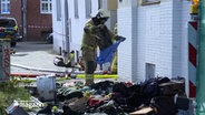 Ein Feuerwehr räumt eine Wohnung leer in Lübeck. © NDR 