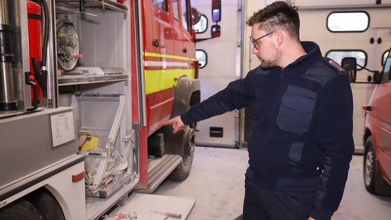 Ein Feuerwehrmann zeigt auf Einbruchsschäden. © Florian Sprenger 