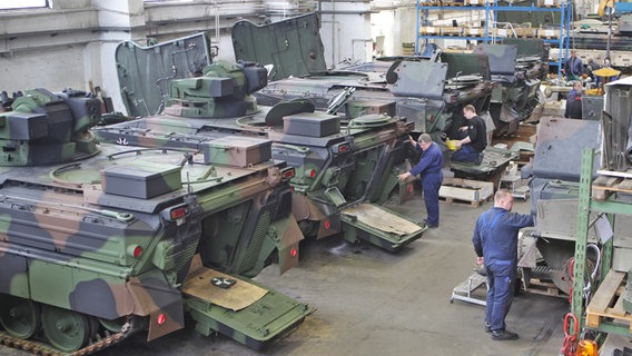 Mitarbeiter der Instandsetzungsabteilung der Flensburger Fahrzeugbau Gesellschaft (FFG) arbeiten an einem Panzer des Typs "Marder" der deutschen Bundeswehr. © picture alliance / Caro Foto: Seeberg