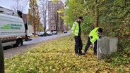 Zwei Techniker der Stadtwerke an einem Stromkasten © NDR Foto: Frank Goldenstein