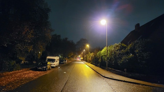 Autos parken auf dem Seitenstreifen einer Straße in Flensburg bei Dunkelheit. © NDR Foto: Frank Goldenstein