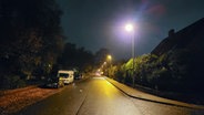 Autos parken auf dem Seitenstreifen einer Straße in Flensburg bei Dunkelheit. © NDR Foto: Frank Goldenstein