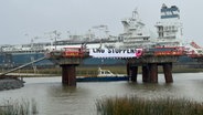 Beim LNG-Terminal in Brunsbüttel wurde bei einer Protestaktion ein Banner mit der Aufschrift "LNG Stoppen" angebracht. © NDR Foto: Marek Walde