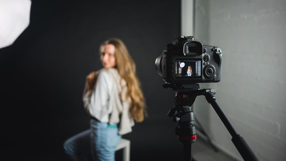 Eine Frau posiert vor einer Kamera in einem fotostudio © picture alliance / Shotshop Foto: Addictive Stock