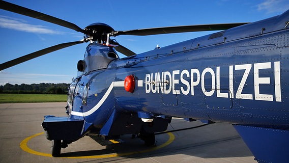 Ein blauer Hubschrauber von schräg hinten, auf dem der Schriftzug der Bundespolizei angebracht ist © dpa-Bildfunk Foto: Axel Heimken