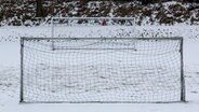 Fußballtore stehen auf einem schneebedeckten Fußballplatz. © dpa Foto: Carsten Rehder