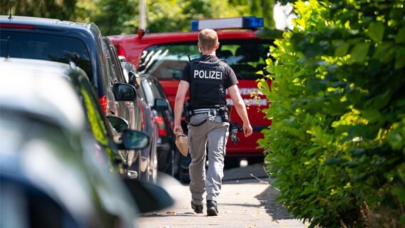 Ein Polizeibeamter nahe des Tatorts. Im Stadtteil Gaarden-Süd/Kronsburg kam es zu einem Tötungsdelikt. © picture alliance/dpa Foto: Jonas Walzberg