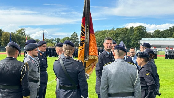 Soldaten der Bundeswehr mit einer Flagge der Bundesrepublik © NDR Foto: Ben Amrstrong