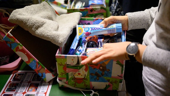 Eine Helferin überprüft den Inhalt eines Geschenke-Schuhkartons der Geschenkaktion «Weihnachten im Schuhkarton». © picture alliance/dpa Foto: Lisa Ducret