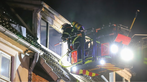 Ein Feuerwehrmann auf einer Drehleiter löscht im zweiten Stock eines Hauses einen Brand. © Florian Sprenger Foto: Florian Sprenger