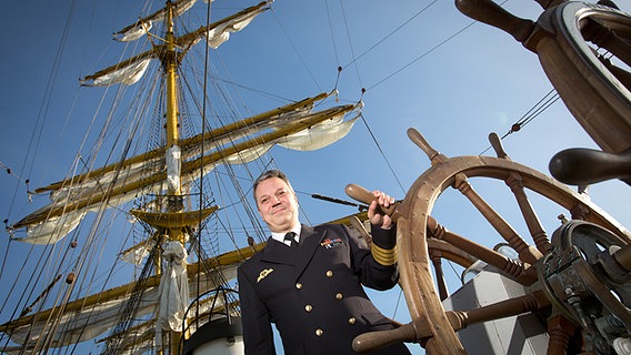 Helge Risch, Kommandant der Gorch Fock, steht an einem Steuerrad des Segelschulschiffs © picture alliance / dpa Foto: Christian Charisius