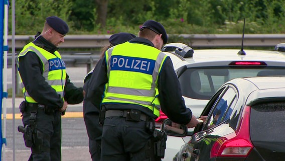 Polizeibeamte kotrollieren Fahrzeuge bei der Einreise an der Deutsch-Dänischen Grenze nahe Flensburg. © NDR 