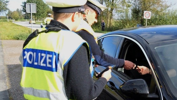 Zwei Polizisten kontrollieren einen nach Deutschland einreisenden PKW-Fahrer. © dpa-Bildfunk Foto: Jörn Hüneke/dpa