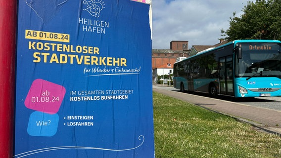 Ein Plakat wirbt für kostenlosen Stadtverkehr in Heiligenhafen. © NDR Foto: Hauke Bülow
