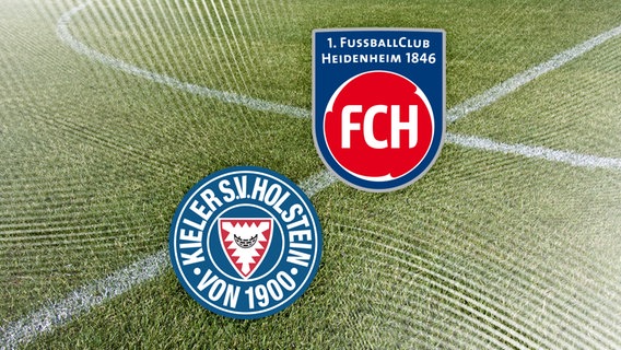 Das Vereinswappen von Holstein Kiel neben dem vom 1. FC Heidenheim vor Fussballrasen. © NDR 