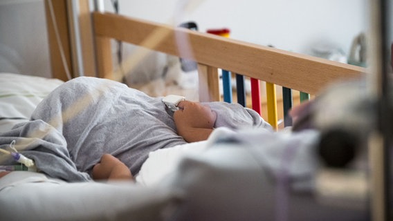 Ein Gast, so werden die Kinder genannt, die sich im Hospiz aufhalten, liegt in einem Bett im Kinder- und Jugendhospiz © picture alliance/dpa | Daniel Vogl Foto: Daniel Vogl