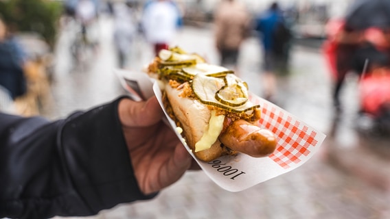 Hand hält einen original dänischen Hotdog. © Picture Alliance Foto: Michael Bihlmayer