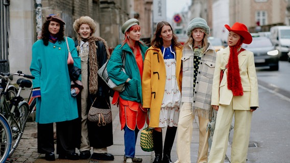 Zur Zeit der Kopenhagener Fashion Week stehen sechs junge Frauen in bunter Kleidung auf dem Gehweg. © IMAGO / ABACAPRESS Foto: Marie-Paola Bertrand-Hillion