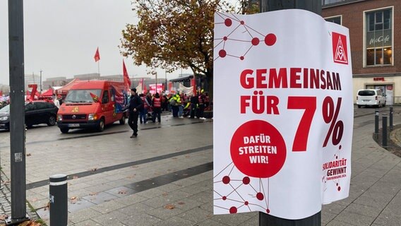 Bei einer Demo der IG Metall am Kieler Bahnhof hängt ein Plakat mit der Aufschrift "Gemeinsam für 7%". © NDR Foto: Joscha Krone