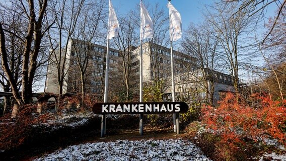 Fahnen mit dem Klinik-Logo wehen vor dem Haupteingang der Imland-Klinik. © picture alliance/dpa Foto: Axel Heimken