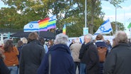 Mehrere Fahnen auf einer Demonstration © NDR Foto: NDR Screenshot