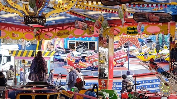 Fahrgeschäfte auf dem Jahrmarkt in Flensburg. Im Vordergrund ein Karussell, im Hintergrund der "Breakdancer". © NDR Foto: Peer-Axel Kroeske