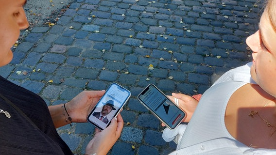 Nele und Julia halten ihre Smartphones in der Hand mit geöffneter App © NDR Foto: Katharina van der Beek
