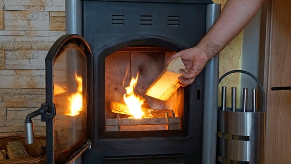 Ein Holzofen in einem Wohnzimmer in Betrieb. © picture alliance / M.i.S. Foto: Bernd Feil