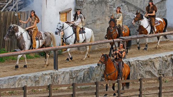 Darsteller der Karl-May Spiele reiten auf Pferden in der Arena am Kalkberg. © KARL-MAY-SPIELE BAD SEGEBERG 