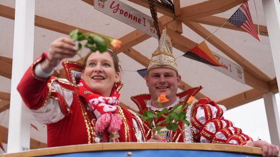 Yvonne und Tim, das Prinzenpaar, werfen Rosen von einem Festwagen während des Rosenmontagsumzugs in Marne. © dpa-Bildfunk Foto: Marcus Brandt