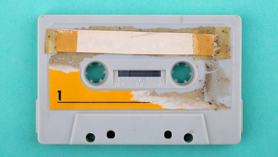 Eine unbeschriftete und abgenutzte Musikkassette. © IMAGO / Shotshop 