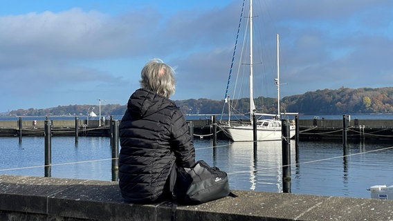 Bernhard S. sitzt bei schönstem Wetter an der Kiellinie und genießt den Ausblick. © NDR Foto: Anke Rösler