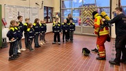 Kleine Kinder stehen in einer Halle der Feuerwehr in Marne. © NDR Foto: Jonas Salto