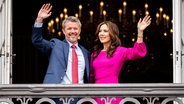 Dänemarks König Frederik X. winkt mit seiner Frau Königin Mary vom Balkon des Palastes von Frederik VIII., Schloss Amalienborg in Kopenhagen. © Ida Marie Odgaard/Ritzau Scanpix /AP/dpa 