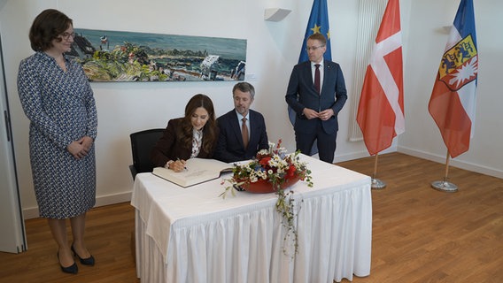 König Frederik X. von Dänemark und Königin Mary von Dänemark tragen sich ins Gästebuch im Gästehaus der Schleswig-Holsteinischen Landesregierung ein © dpa-Bildfunk Foto: Marcus Brandt